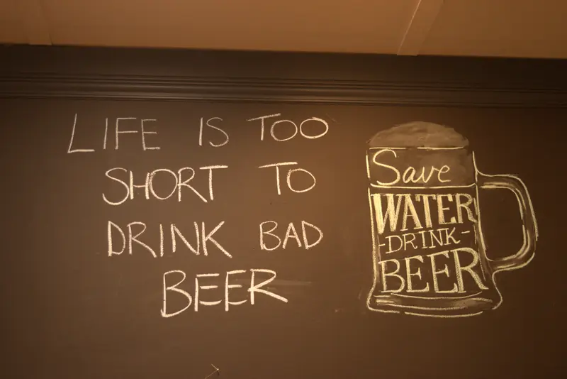 Chalkboard on the wall reading Life is too short to drink bad beer, with a drawing of a beer stein