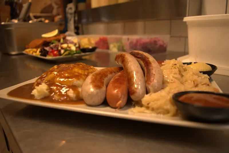 Plate of traditional German sausages with mash, gravy and sauerkraut